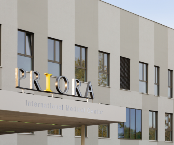 Zgrada s natpisom "PRIORA International Medical Center" iznad ulaza, s modernim, svijetlosivim pročeljem i velikim prozorima.