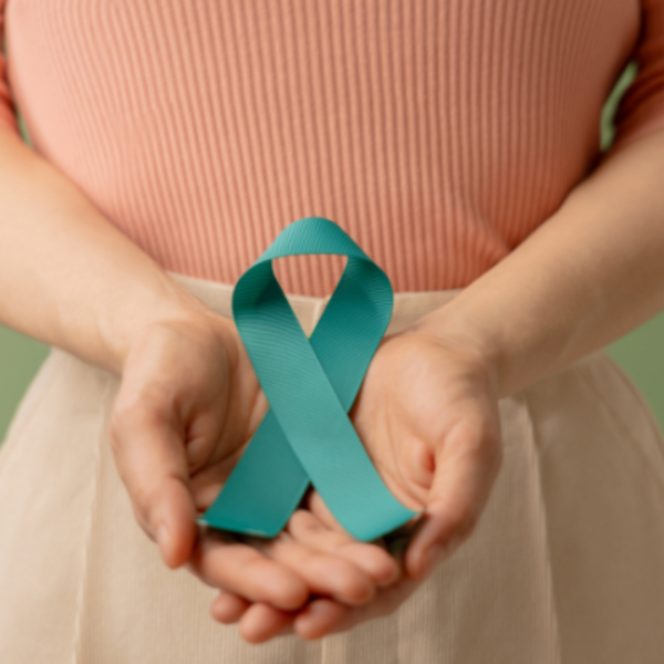 Tirkizna vrpca za podizanje svijesti u sklopljenim dlanovima.